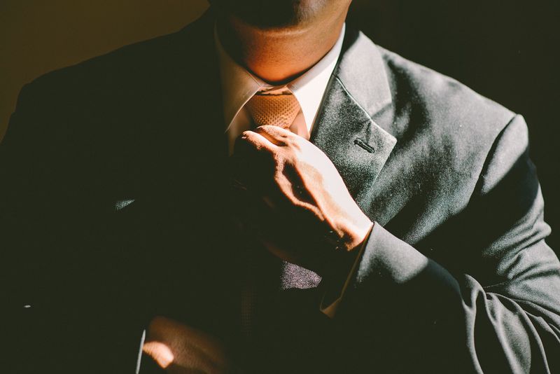 File:Man in suit tightening tie.jpg